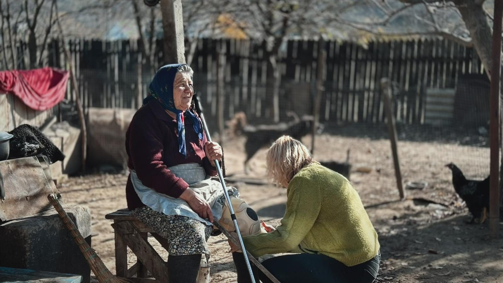 A volunteer sitting with an older resident in Lăpușna